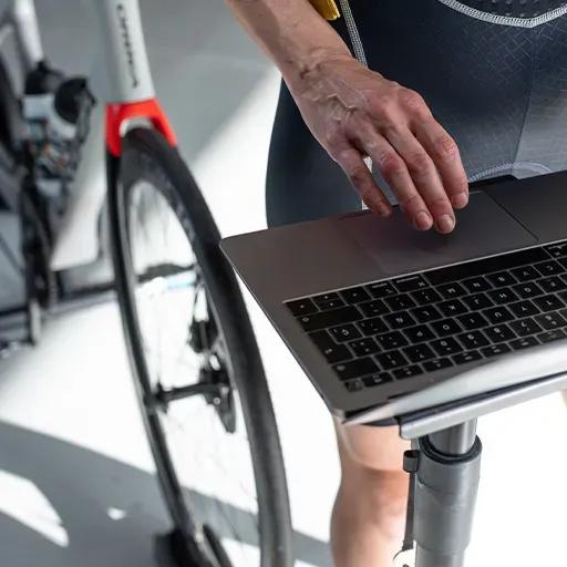 Cyclist accessing the BKOOL virtual bike simulator on his laptop.