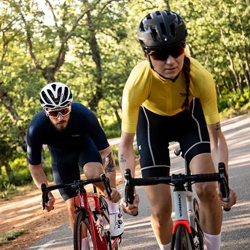 Two cyclists training on an outdoor cycle track.